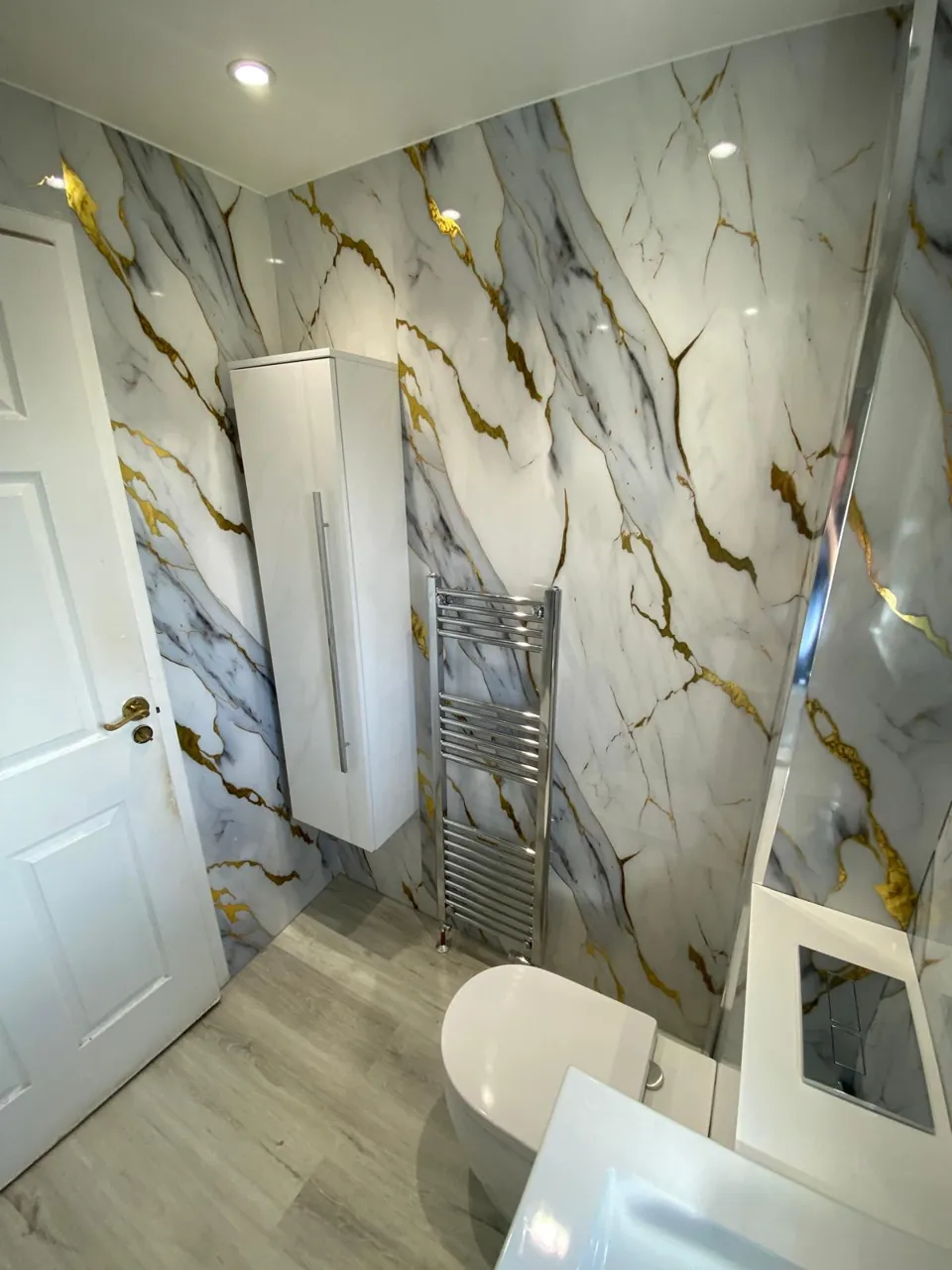 Compact shower room with gold-veined marble-effect walls